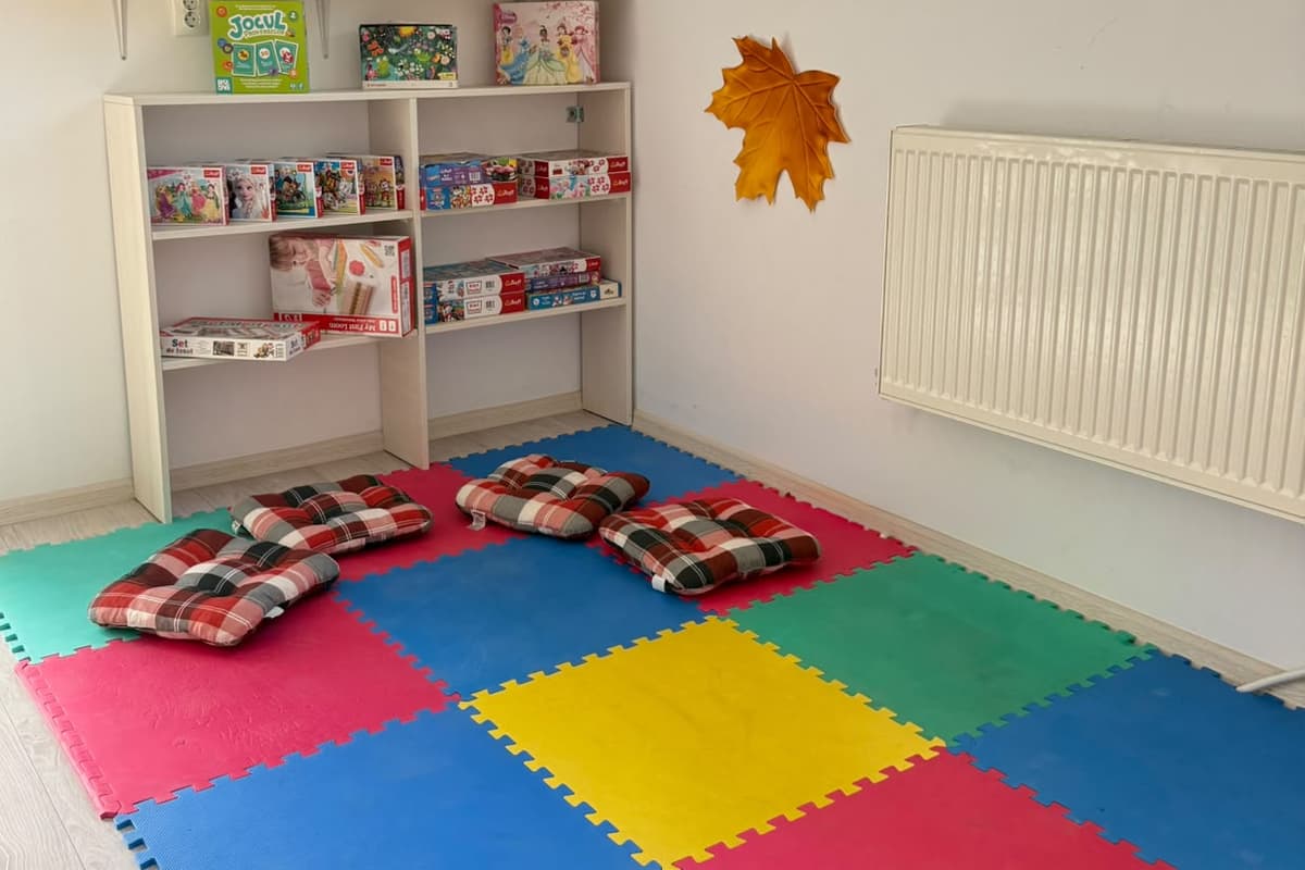 Colțul de lectură, cu covorașe colorate și perne în carouri